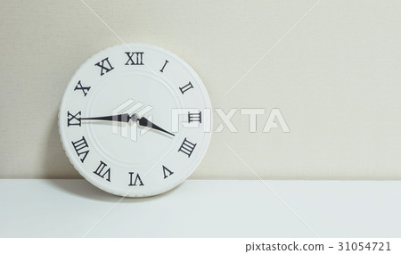 white clock on white wood desk and cream wallpaper white clock on white wood desk and cream wallpaper 31054721