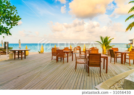 Table and chairs at restaurant in tropical Maldives island . Table and chairs at restaurant in tropical Maldives island . 31056430
