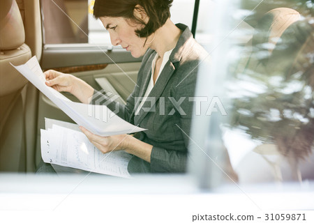 Businesswoman reading documents on backseat of the car 31059871