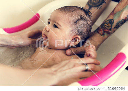 Father and mother are taking care of their child. 31060064