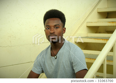 young man sitting in the stairs concrete wall young man sitting in the stairs concrete wall 31063700