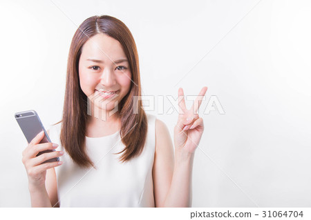 一個年輕的女人用智能手機把一塊放在她的手上 31064704