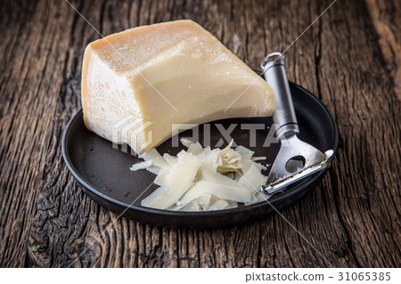 Parmesan cheese on old table with cheese grater. 31065385