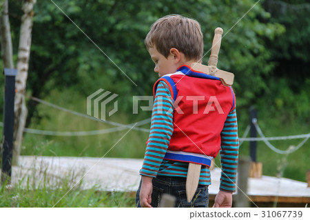 Boy with wooden sword in summer forest park 31067739