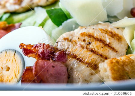 Ceasar salad with quail egg lettuce bacon crutons. 31069605