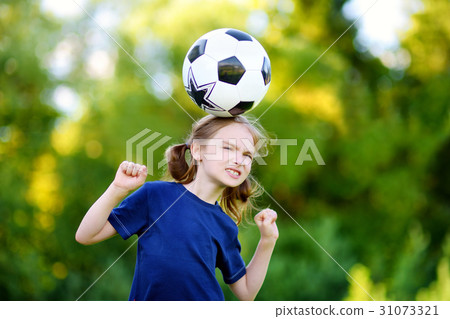 Cute little girl having fun playing a soccer game 31073321