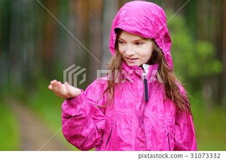 Adorable little girl playing happily in the rain 31073332