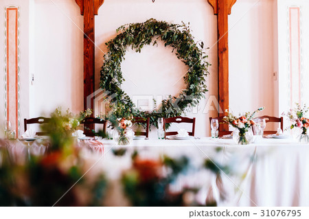 Dinner table stands before wall decorated Dinner table stands before wall decorated 31076795