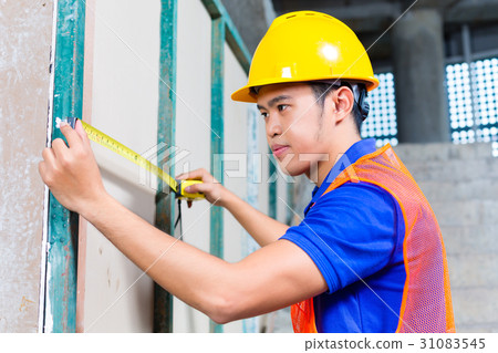 worker controlling wall on construction site worker controlling wall on construction site 31083545
