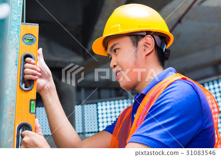 Builder controlling wall on construction site Builder controlling wall on construction site 31083546