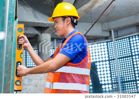 Builder controlling wall on construction site 31083547