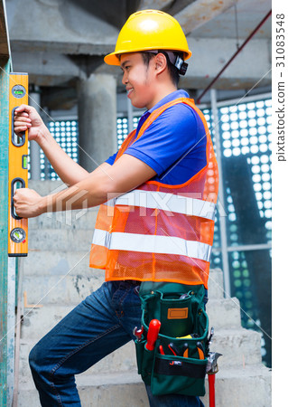 worker controlling wall on construction site 31083548