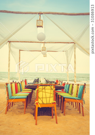 Table and chair set on the beach for dinner Table and chair set on the beach for dinner 31086913