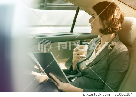 Businesswoman using digital tablet on backseat of the car 31091194