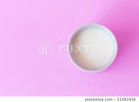 Closeup top view milk in white ceramic cup on pink 31092916