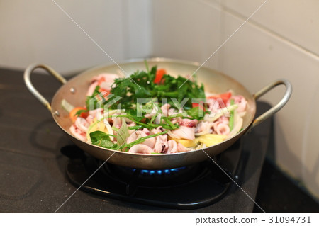 Happy housewife cooking squid with seafood in home Happy housewife cooking squid with seafood in home 31094731