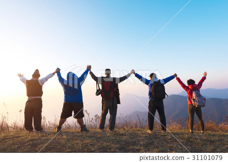 Group of people stands on the top of mountain 31101079