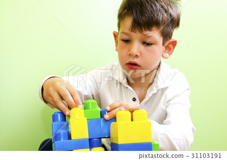 boy playing with construction toy blocks 31103191