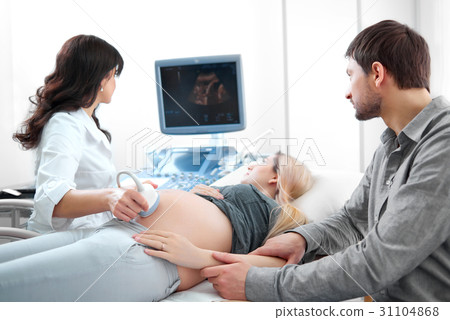 Doctor diagnosing pregnant woman in modern 31104868