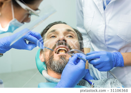 Dental doctors working with patient. 31106368