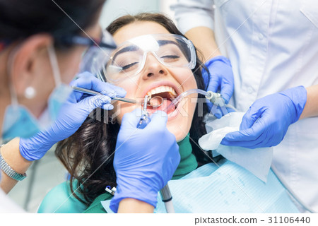 Two dentists busy with patient. Two dentists busy with patient. 31106440