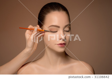 Beautiful female eyes with make-up and brush Beautiful female eyes with make-up and brush 31106642