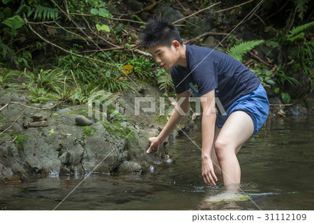 Boy playing in the mountains, playing in the water 31112109