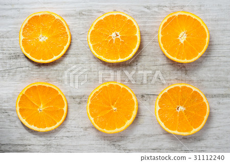Six slices of fresh oranges on white wood 31112240