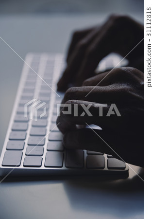 young man typing in a computer keyboard 31112818