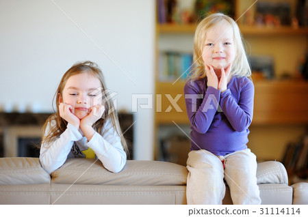 Two little sisters having fun at home 31114114
