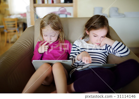 Two little sisters having fun using digital tablet 31114146