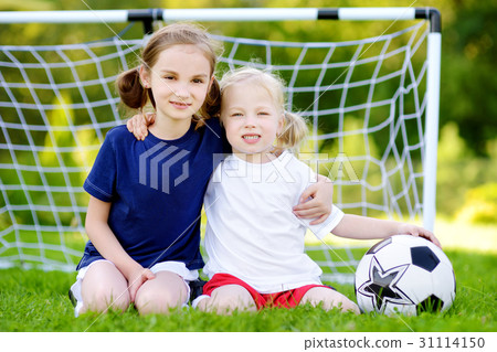Two cute little sisters playing a soccer game 31114150