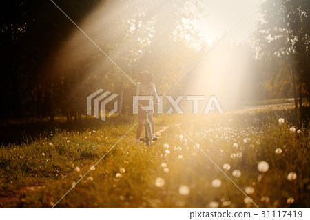 Funny girl driving bicycle outdoor. Sunny summer 31117419