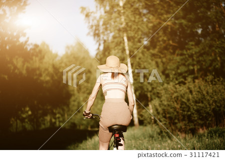 Funny girl driving bicycle outdoor. Sunny summer Funny girl driving bicycle outdoor. Sunny summer 31117421