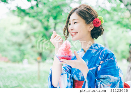 A woman in a yukata eating shaved ice A woman in a yukata eating shaved ice 31123636