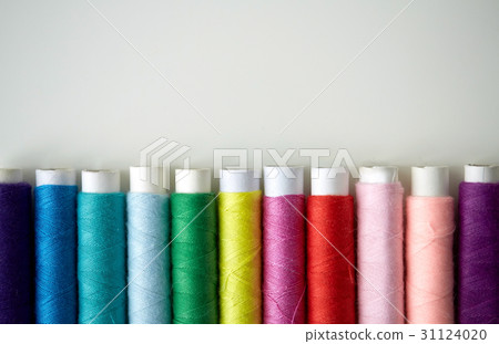 row of colorful thread spools on table row of colorful thread spools on table 31124020