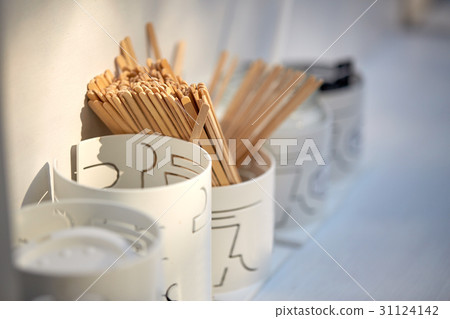 wooden drink stirrers in holder on table 31124142