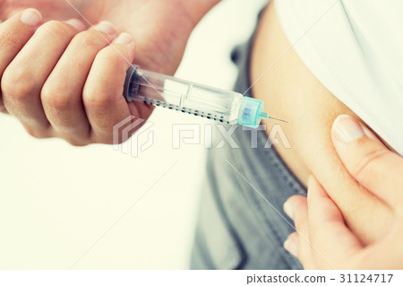 close up of hands making injection by insulin pen 31124717