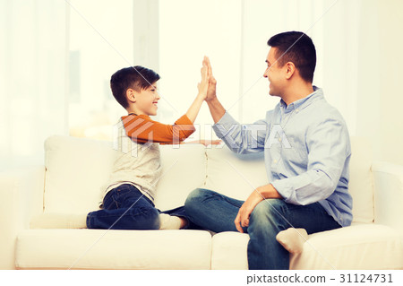 happy father and son doing high five at home happy father and son doing high five at home 31124731