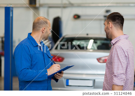 auto mechanic with clipboard and man at car shop auto mechanic with clipboard and man at car shop 31124846