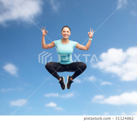 happy smiling sporty young woman jumping in air 31124862