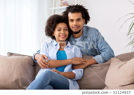 happy couple sitting on sofa and hugging at home 31124937