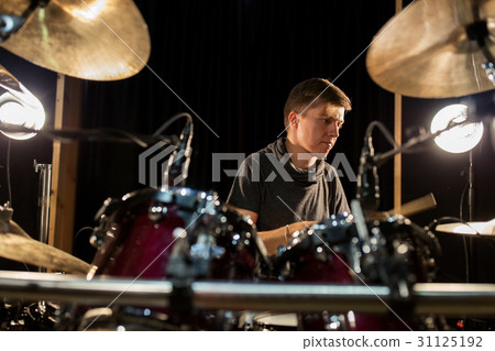 male musician playing drums and cymbals at concert 31125192