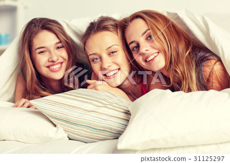 happy young women in bed at home pajama party happy young women in bed at home pajama party 31125297