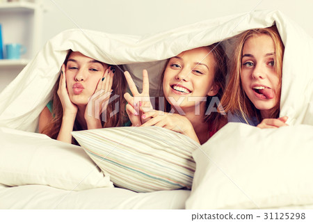 happy young women in bed at home pajama party happy young women in bed at home pajama party 31125298