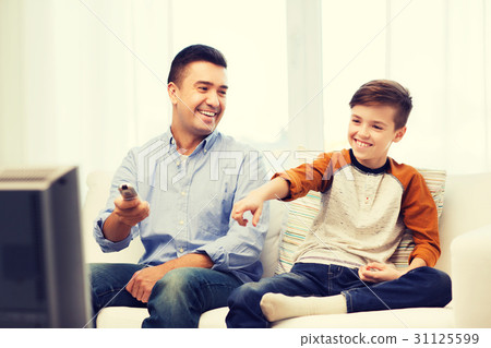 smiling father and son watching tv at home 31125599