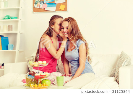 young women drinking tea and gossiping at home 31125844