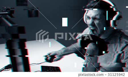 man in headset playing computer video game at home man in headset playing computer video game at home 31125942