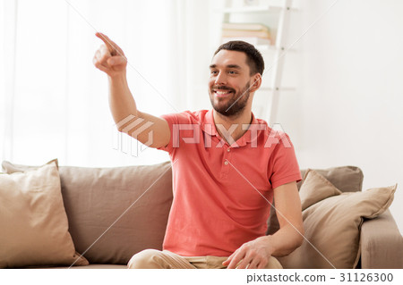 happy man touching something imaginary at home 31126300