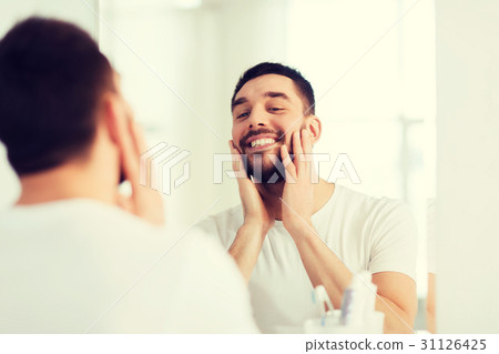 happy young man looking to mirror at home bathroom happy young man looking to mirror at home bathroom 31126425